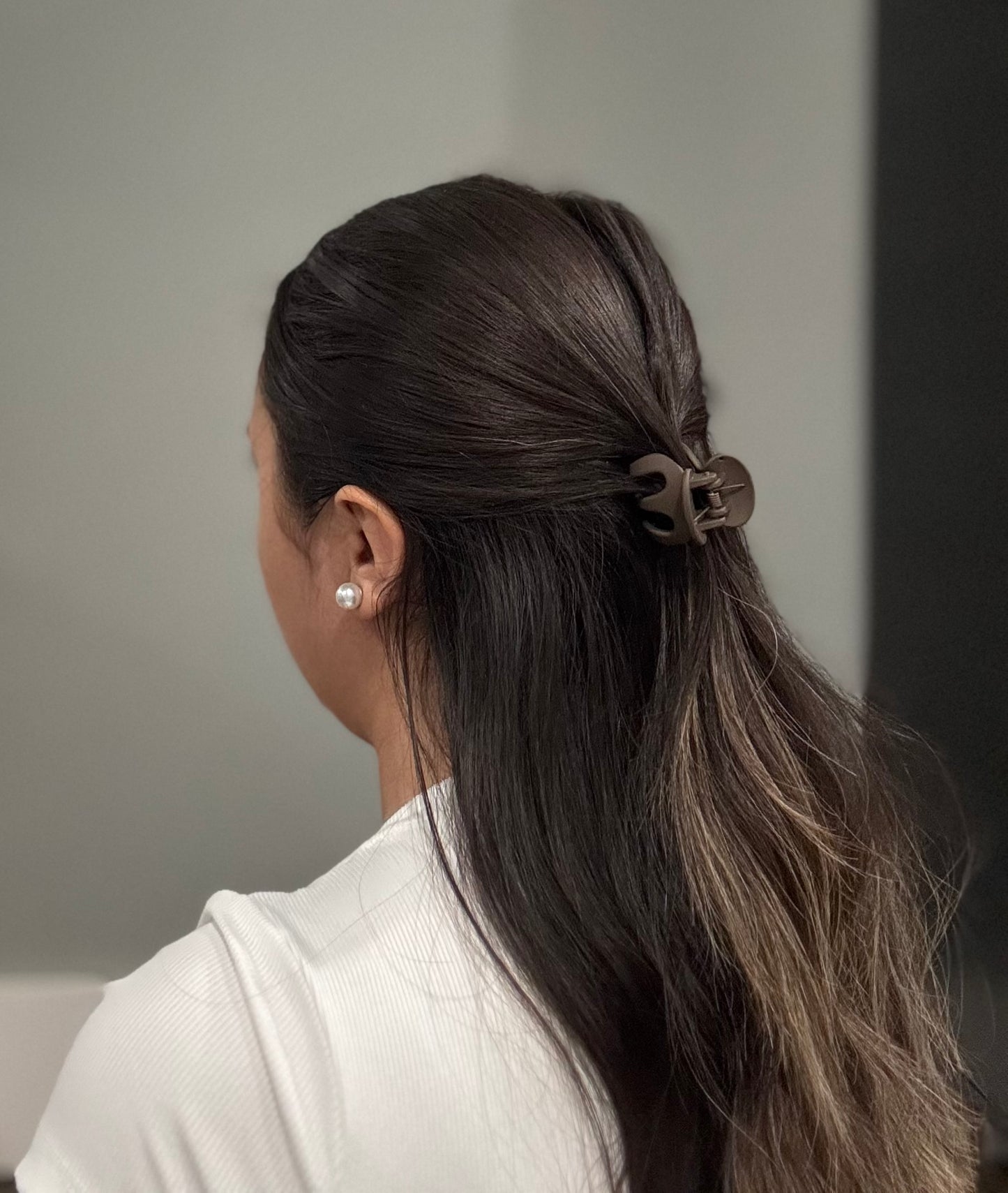 Model wearing EMPIECE™ The Lucía Clip in noir black matte resin, elegant everyday styling.