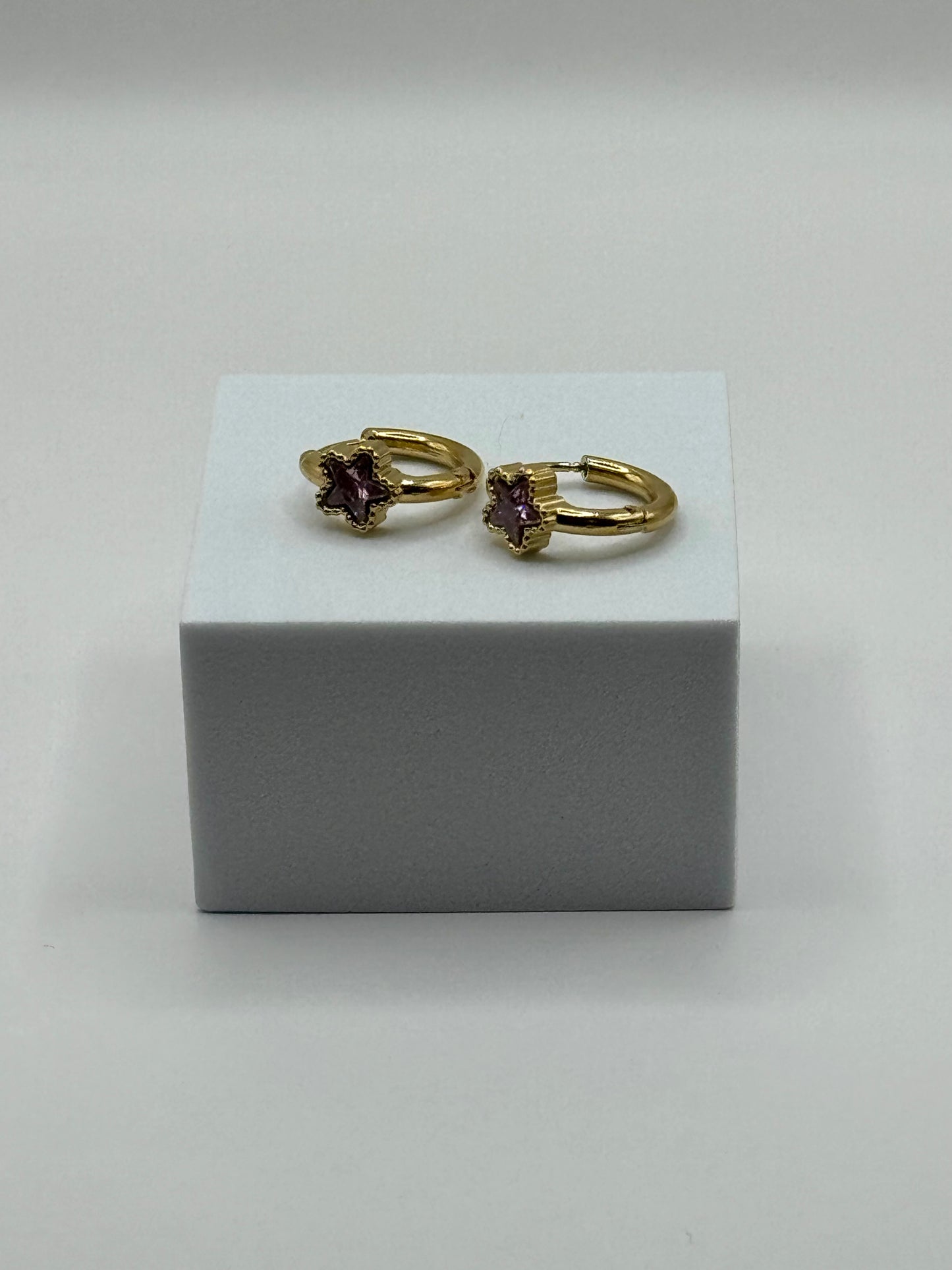 The Aubergine Hoops displayed on white stand with shadow showing size and gold finish with star-shaped stones.