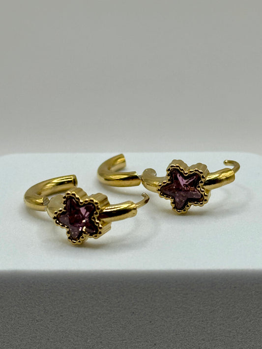 The Aubergine Hoops pair of gold hoop earrings with purple gemstone detail side view on white surface.