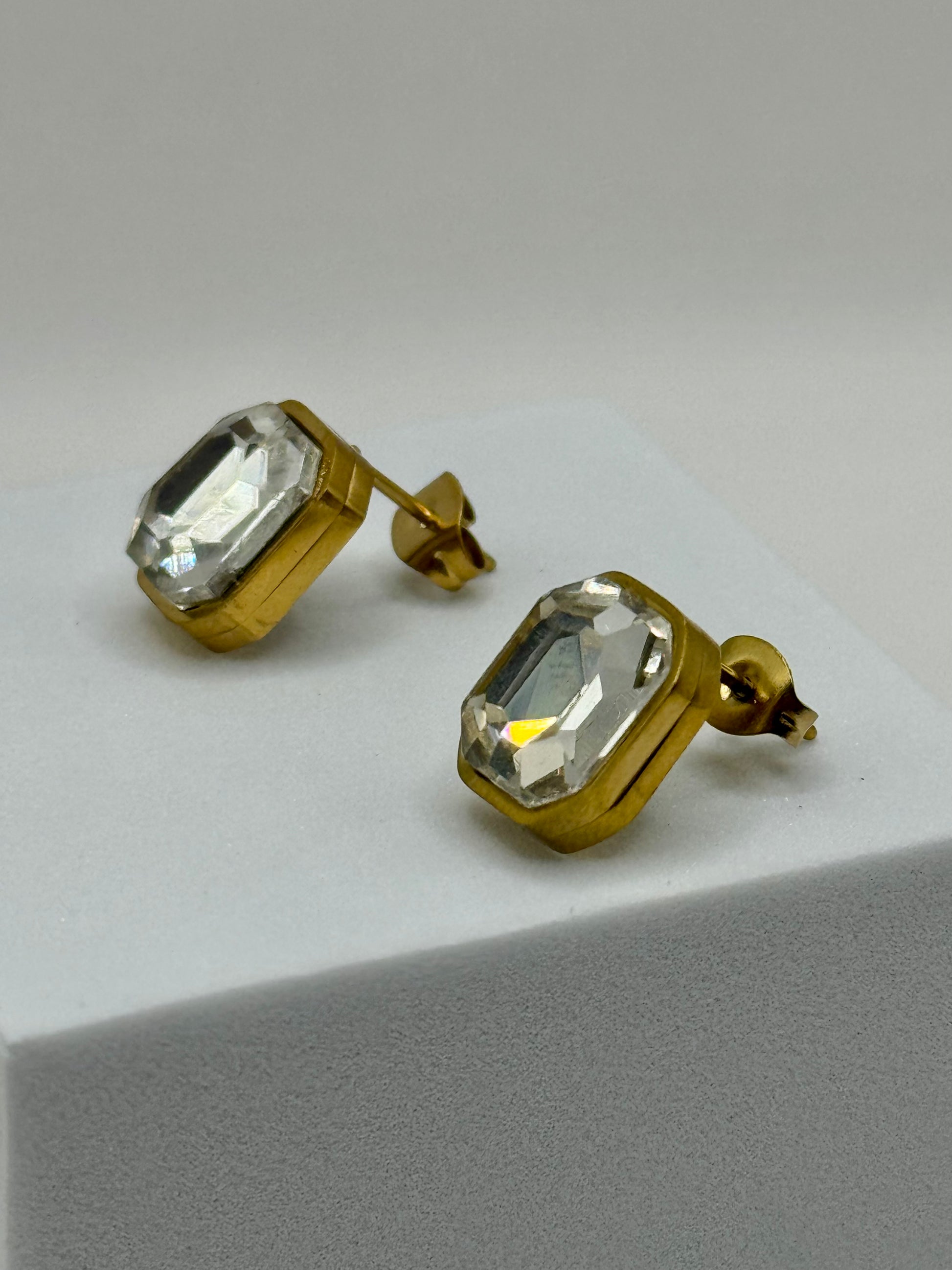 Earrings displayed at an angle to show depth, shine, and craftsmanship of the setting.