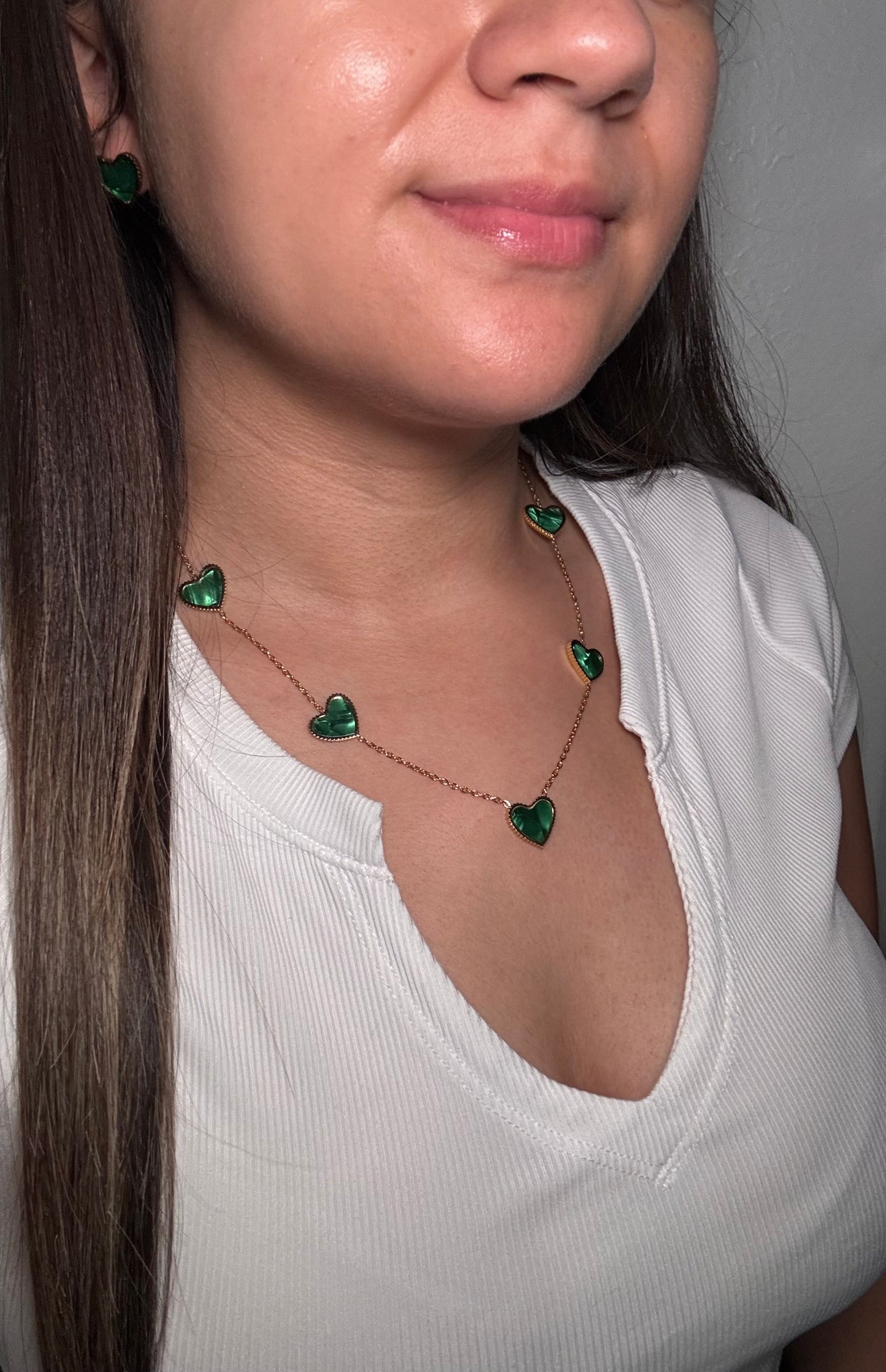 Evergreen Hearts necklace worn by model closer crop of neckline showing layered green heart pendants with golfd finish.