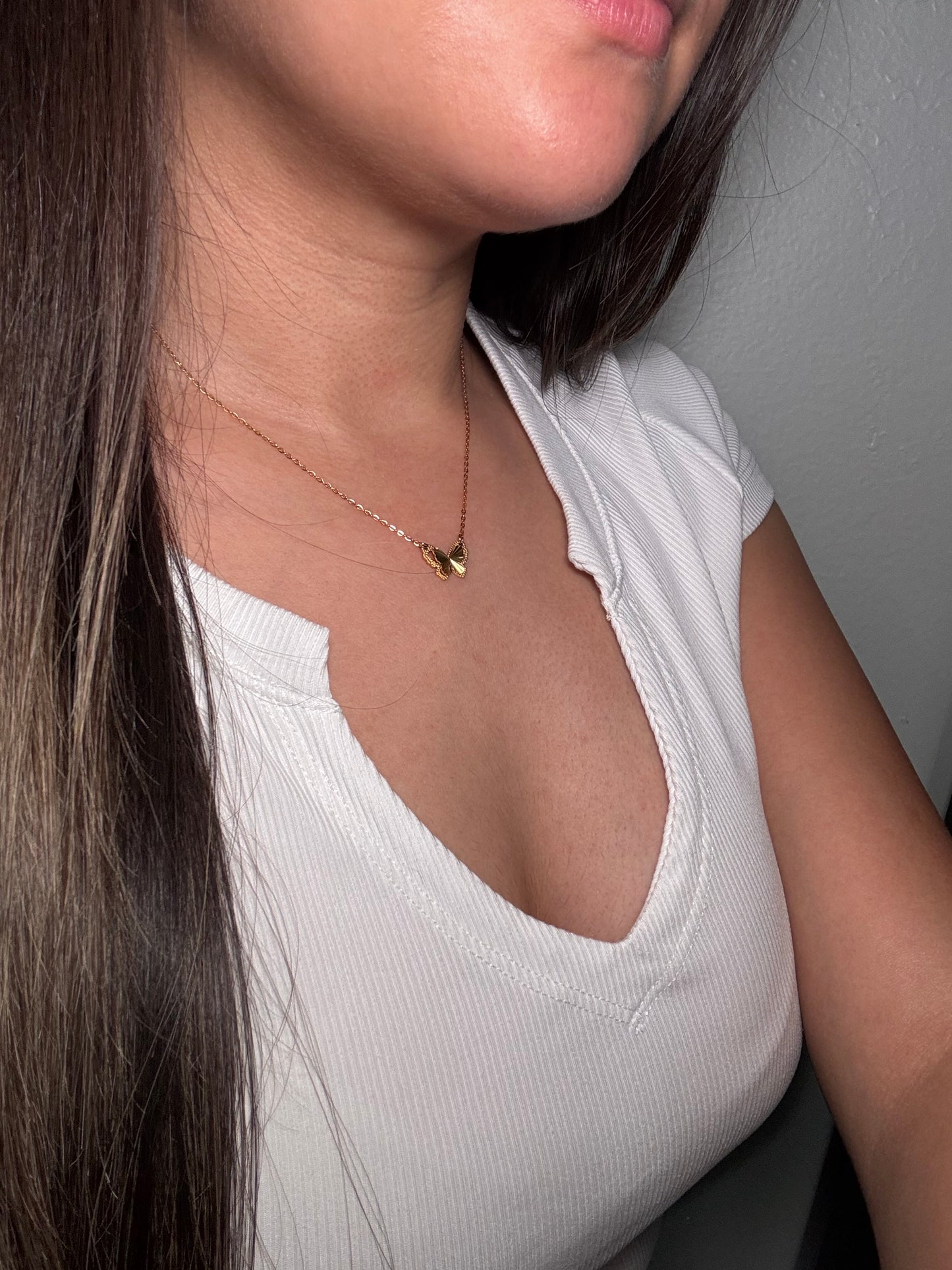 Evergreen Hearts necklace worn by model close-up at neckline with green heart charms resting at collarbone.