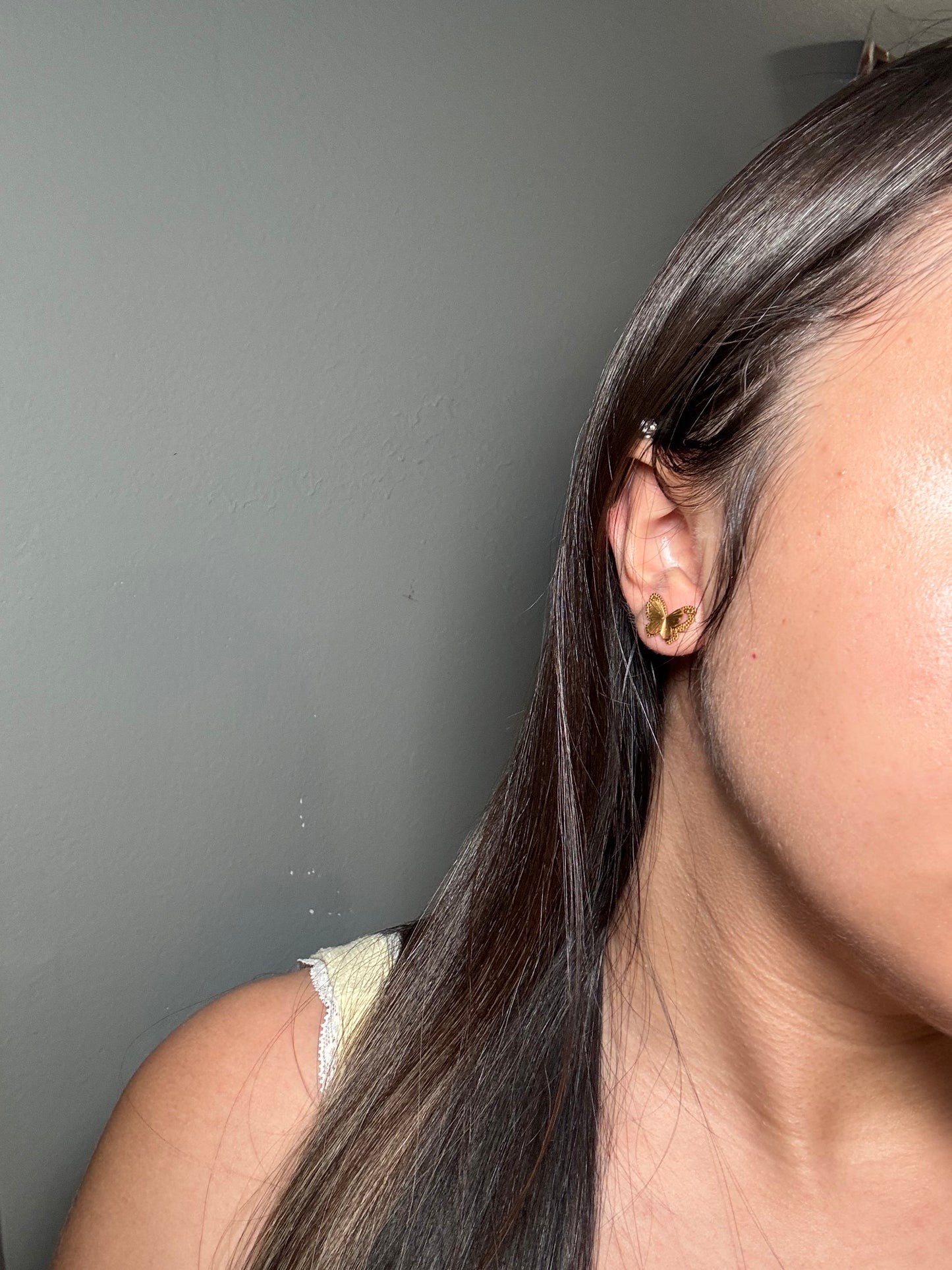 Model wearing Aurora Clásica butterfly stud earrings.