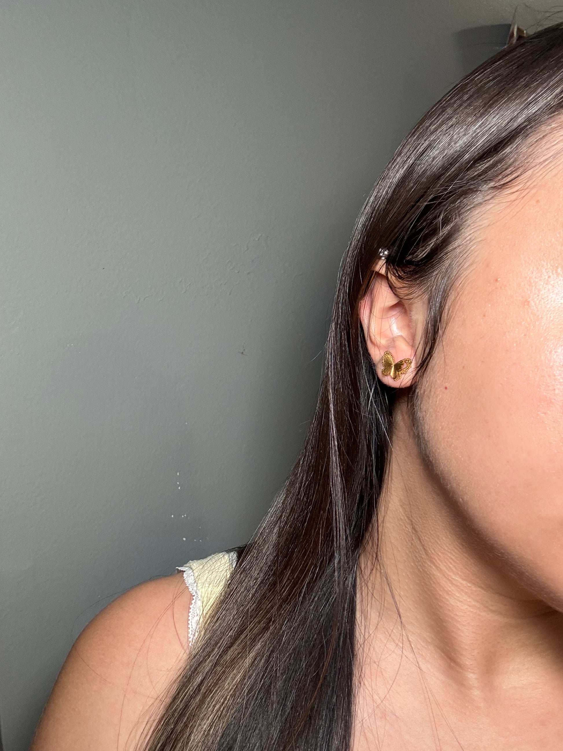 Model wearing Aurora Clásica butterfly stud earrings.