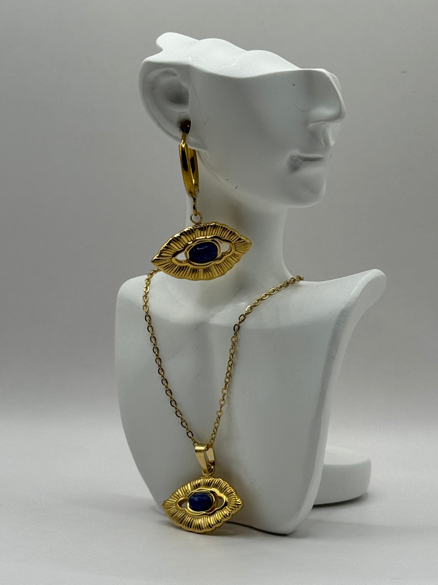 Orovie necklace displayed on white bust stand, showcasing gold frame and cobalt eye pendant.
