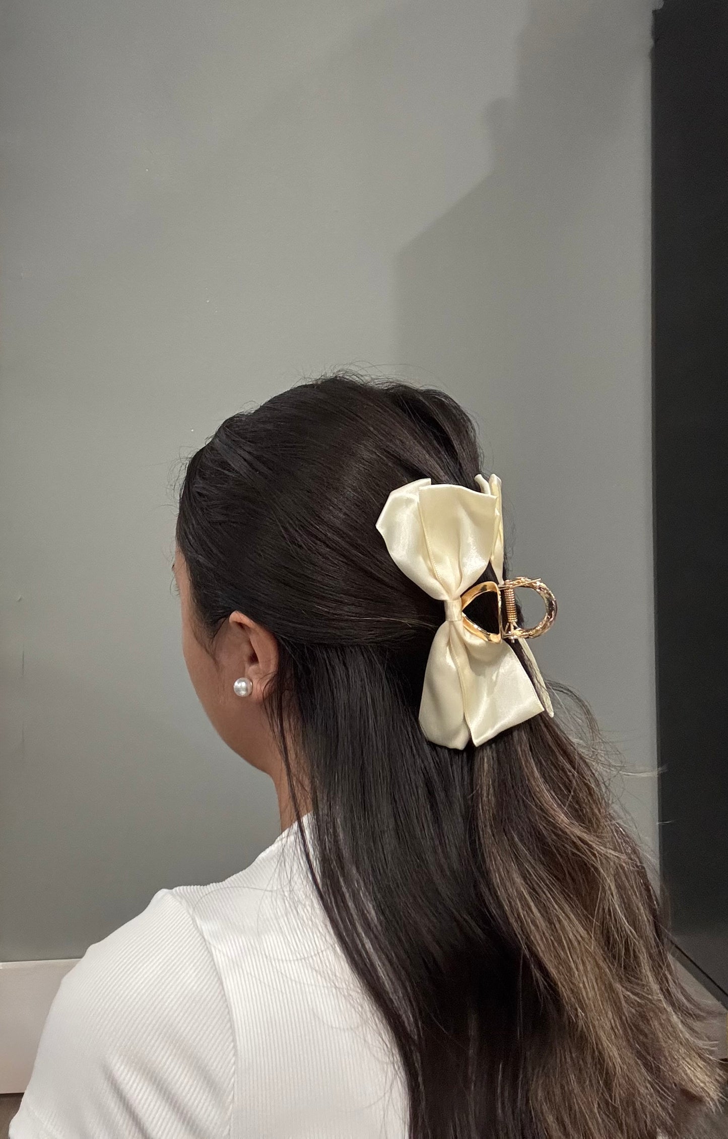 Model wearing EMPIECE™ Paloma Hair Clip in ivory satin bow, styled in a half-up hairstyle.