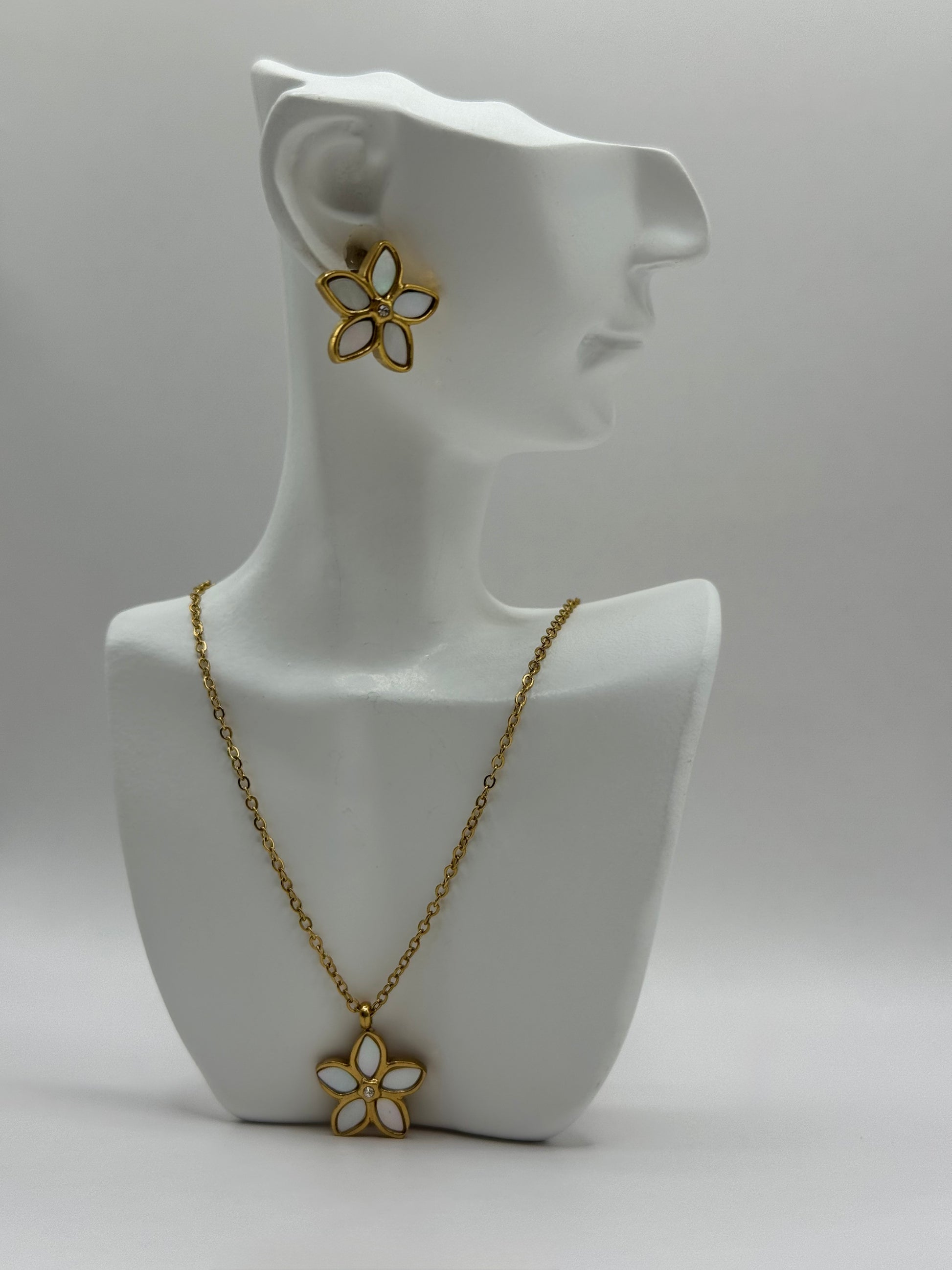 The Opalina necklace and stud earrings displayed upright on white jewelry stand showing floral enamel design.