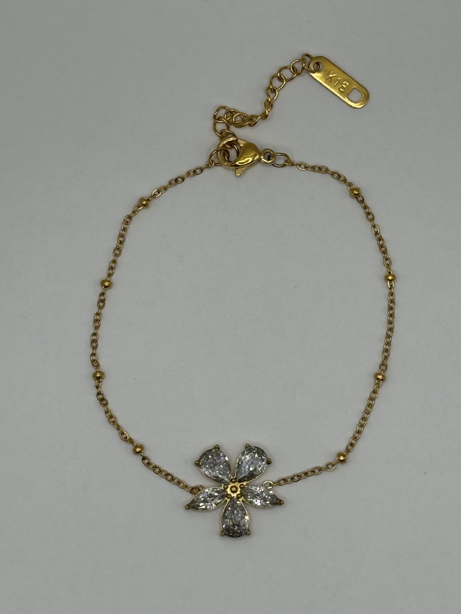 The Zafira Bracelet laid flat, highlighting slender gold chain and polished zircon centerpiece.