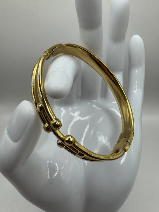 The Colette Bracelet displayed on a white hand model, showcasing its gold-plated finish.