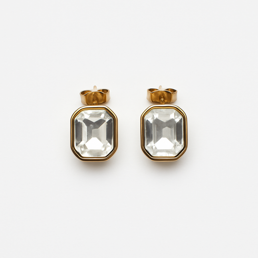 Gold-plated stainless steel studs with clear faceted glass inlay shown against a white background.