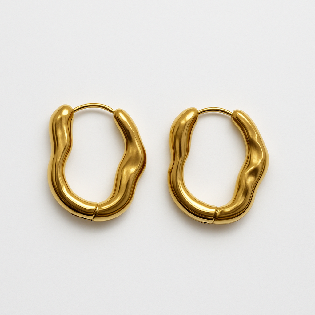 Close-up of EMPIECE™ The Alinéa Hoops gold sculptural earrings with fluid wave design on white background.