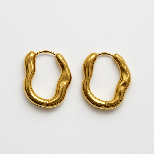 Close-up of EMPIECE™ The Alinéa Hoops gold sculptural earrings with fluid wave design on white background.