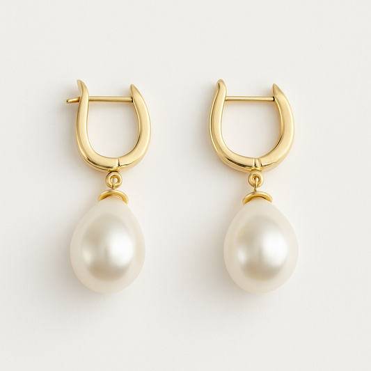 Close-up of The Amara Earrings with gold hoops and radiant pearl drops on white background.
