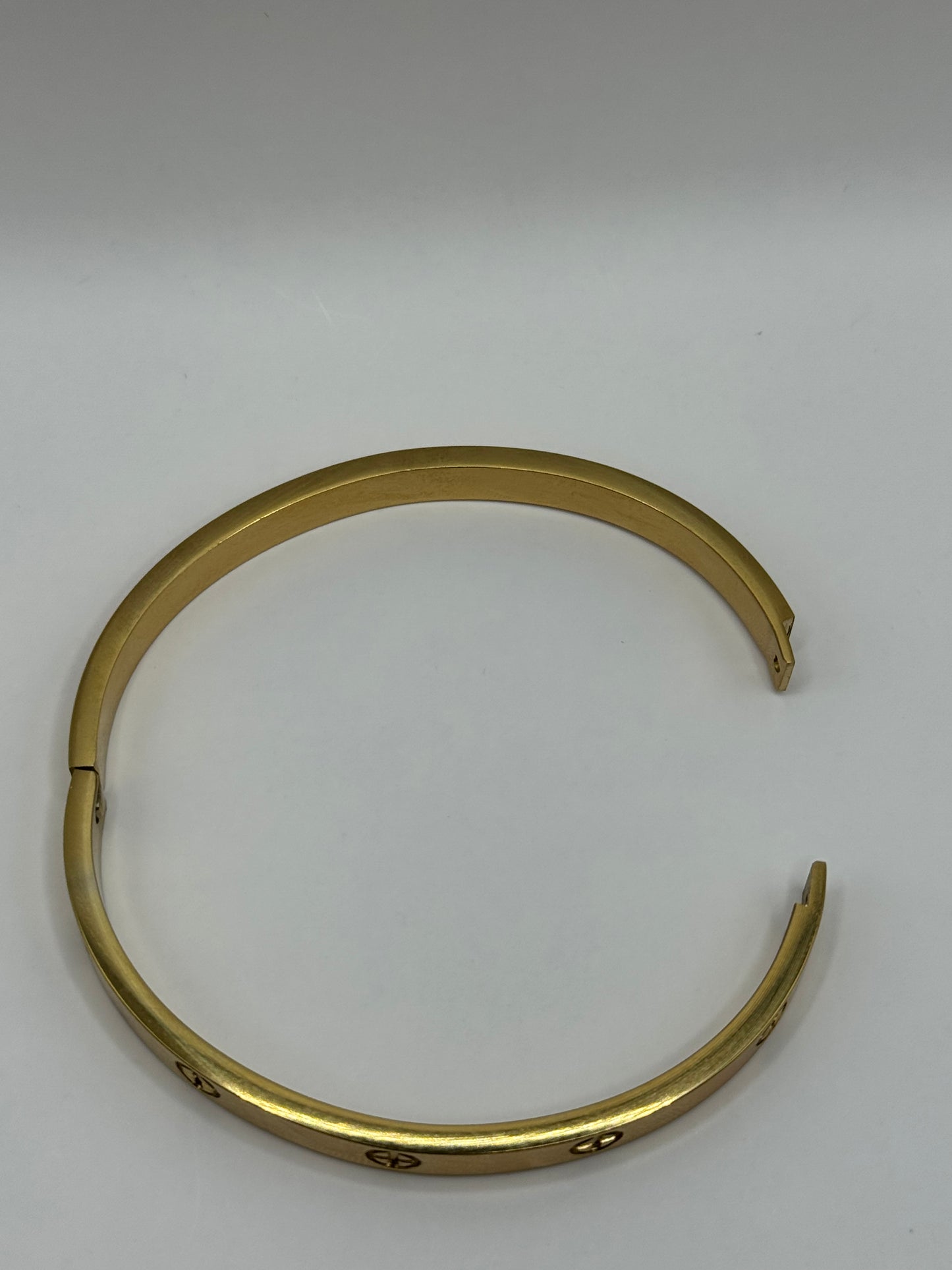 Flat lay of The Eterna Bracelet showing polished gold finish in circular shape.