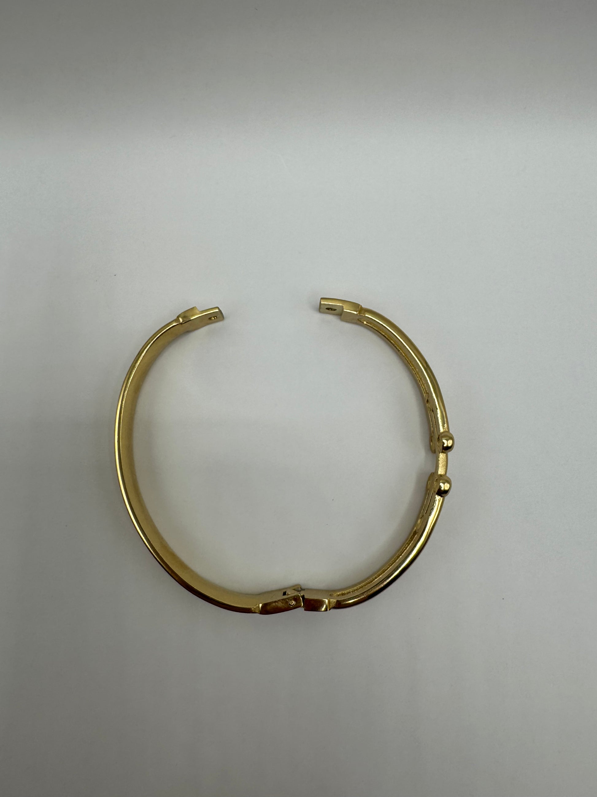 Top view of The Colette Bracelet laid flat, showing its circular gold-plated silhouette with subtle detailing.