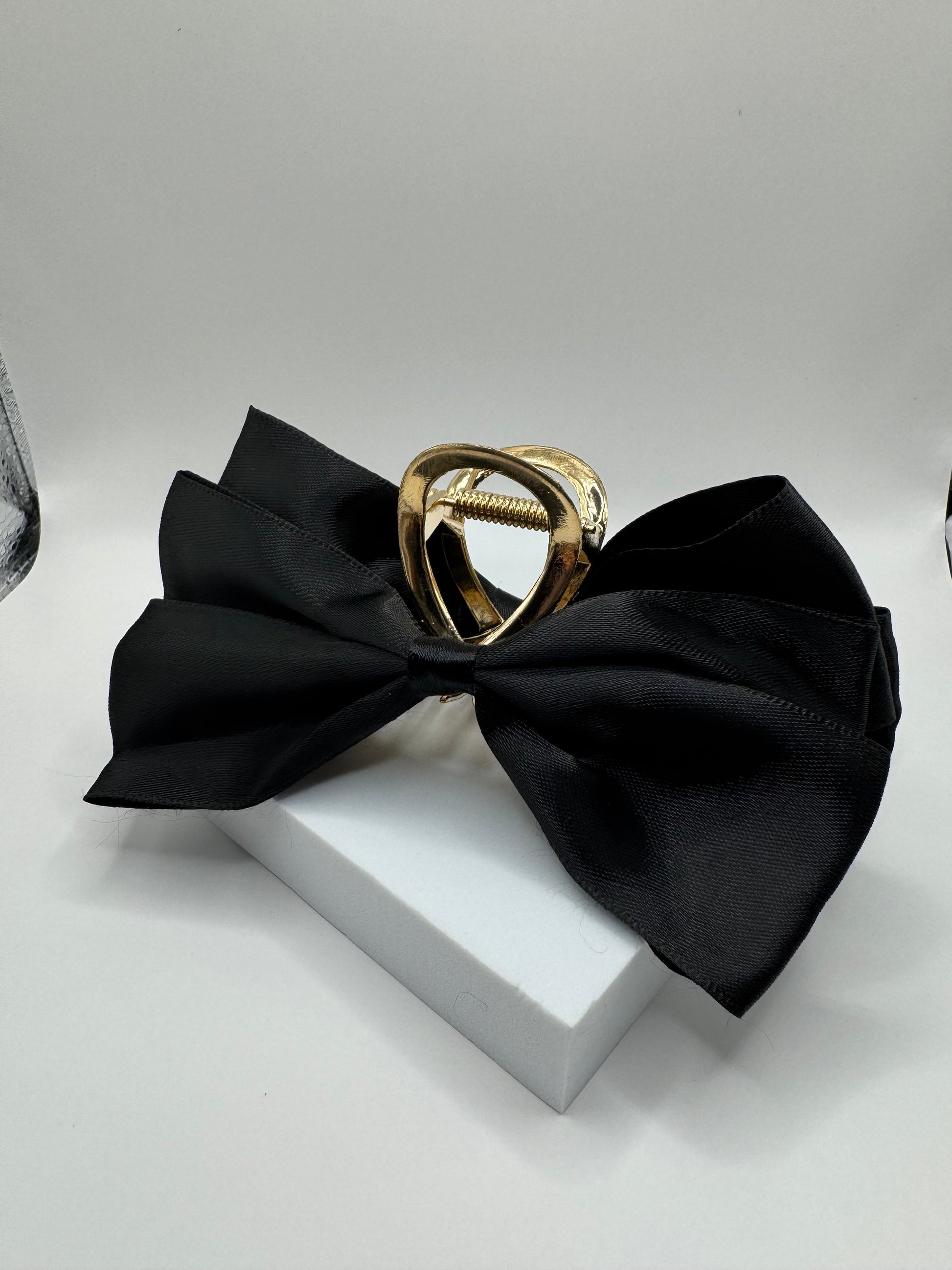 EMPIECE™ Paloma Hair Clip in black satin bow with gold claw on display block.