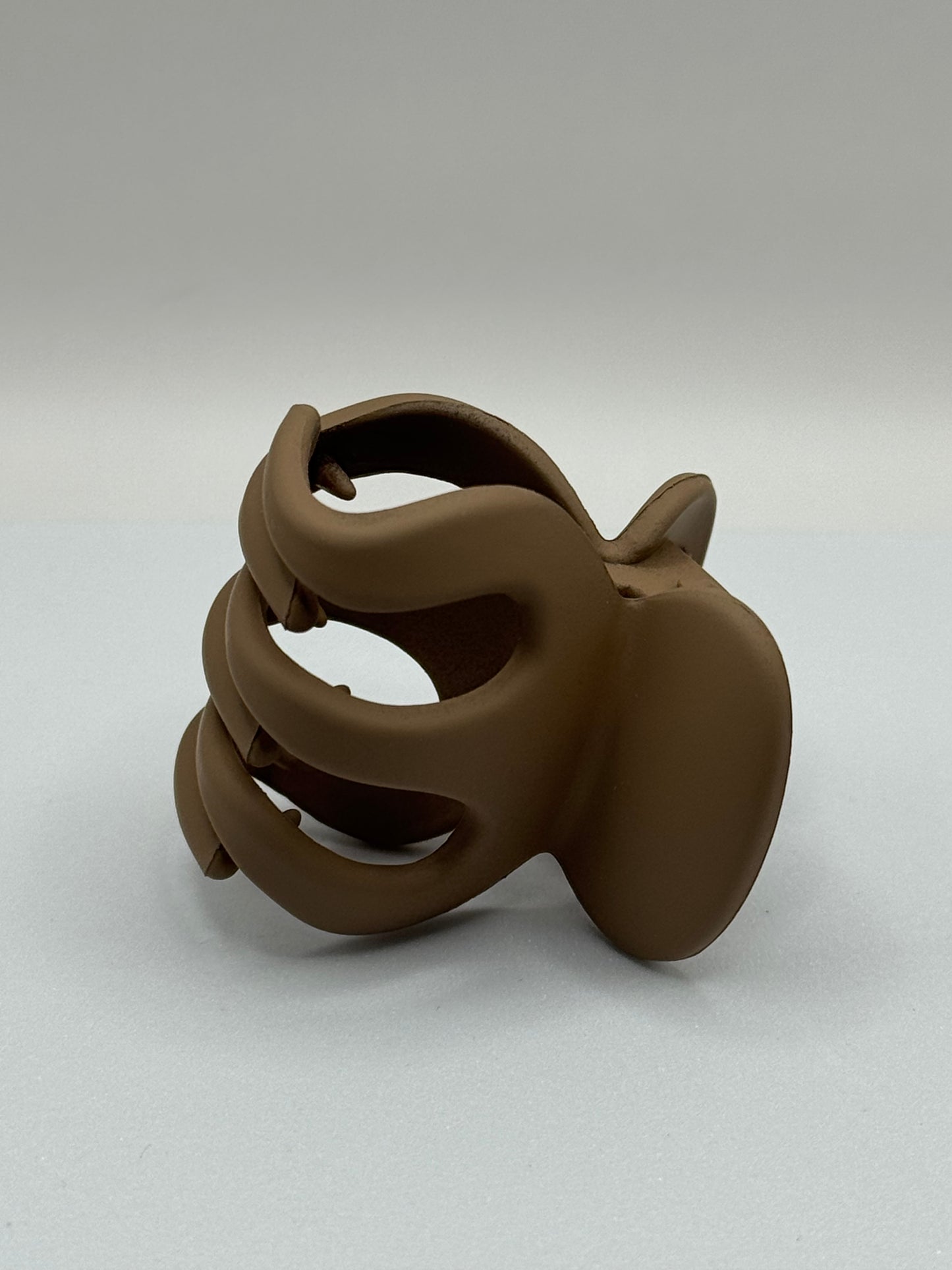 Close-up of EMPIECE™ The Lucía Clip in mocha matte resin, lightweight modern hair accessory.