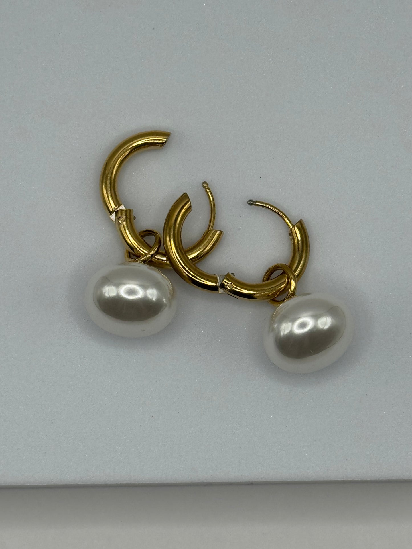 Close-up of The Petaluna Earrings showing gold sculpted petals and round pearl deop detail.