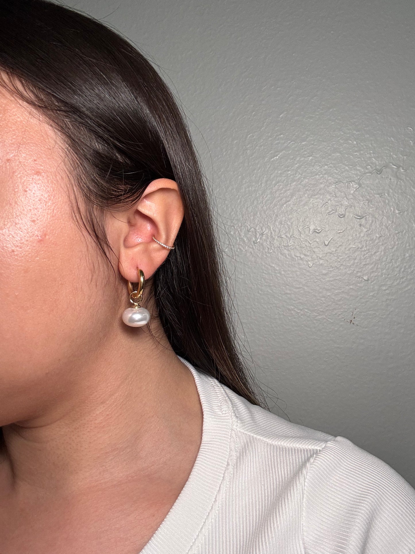 Model wearing The etaluna Earrings, showcasing gold floral esign and pearl drop elegance.