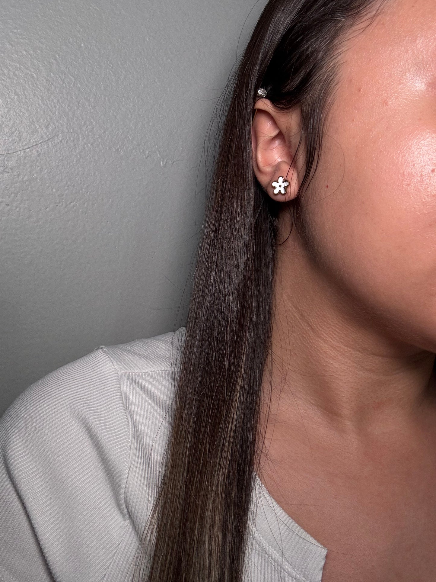 The Gardenia Earrings worn by model close-up on ear for size reference.