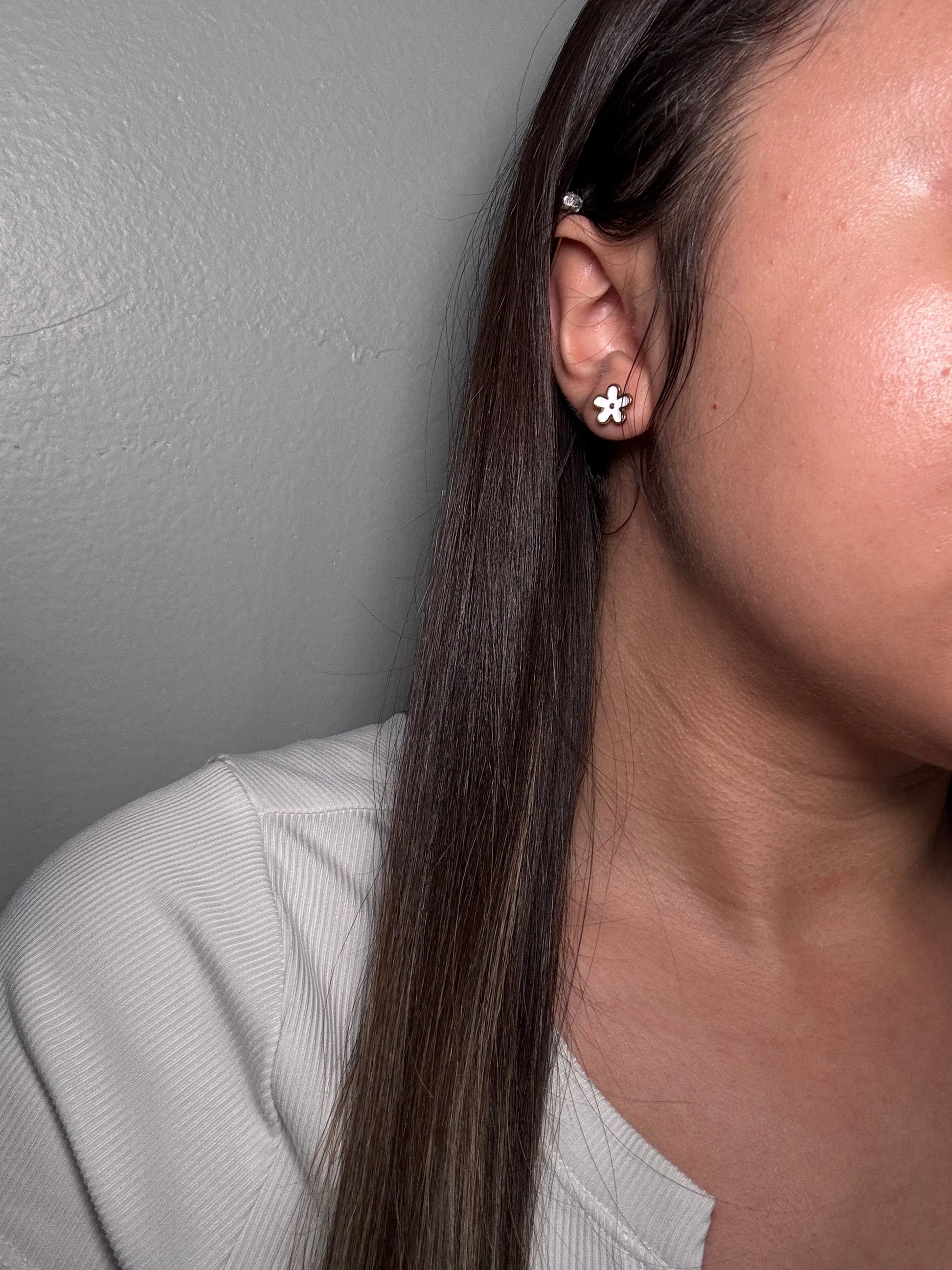 The Gardenia Earrings worn by model close-up on ear for size reference.