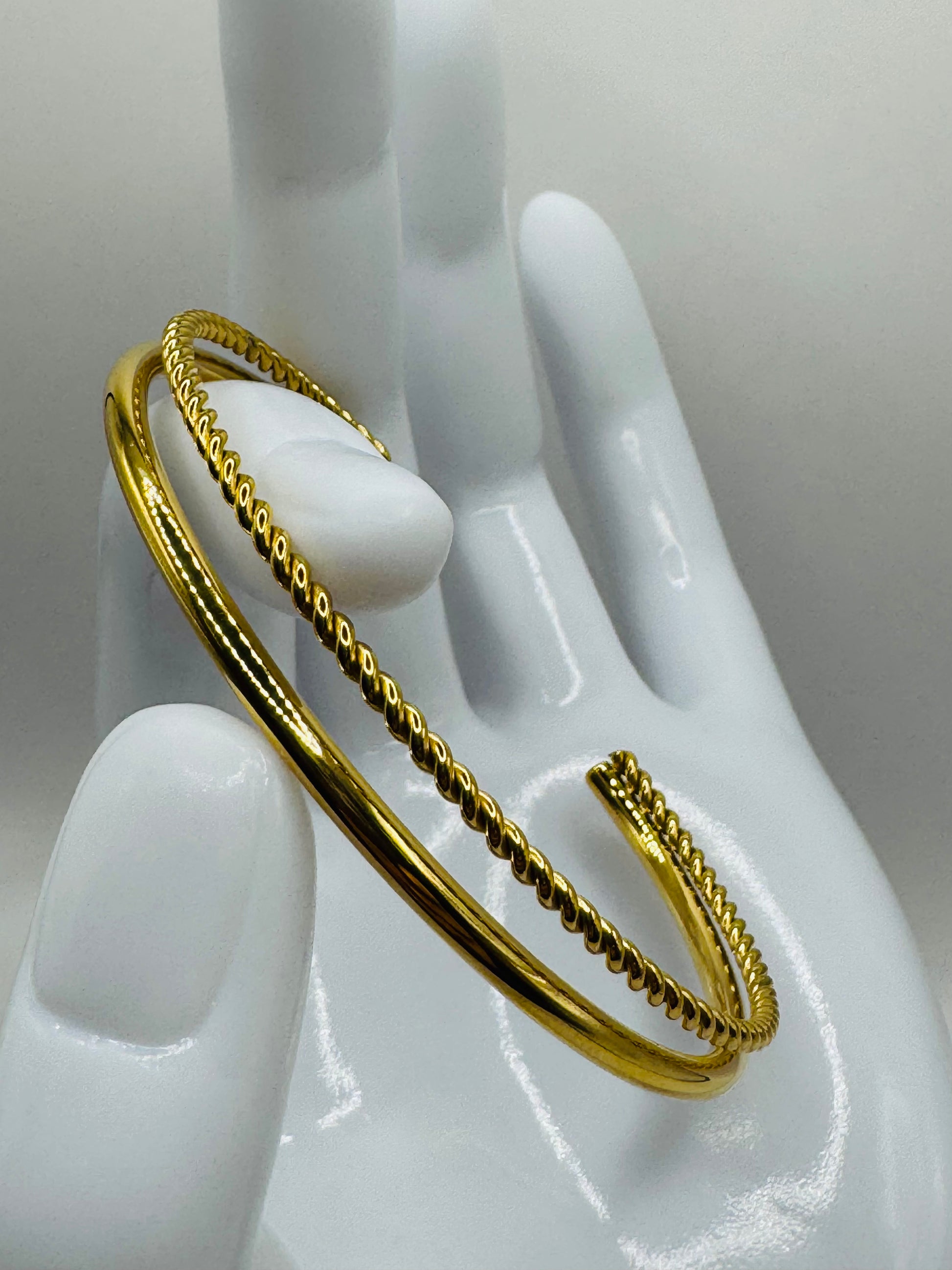 Gold Orion Bracelet displayed on a mannequin hand, showing ridged detailing and open-ended design.
