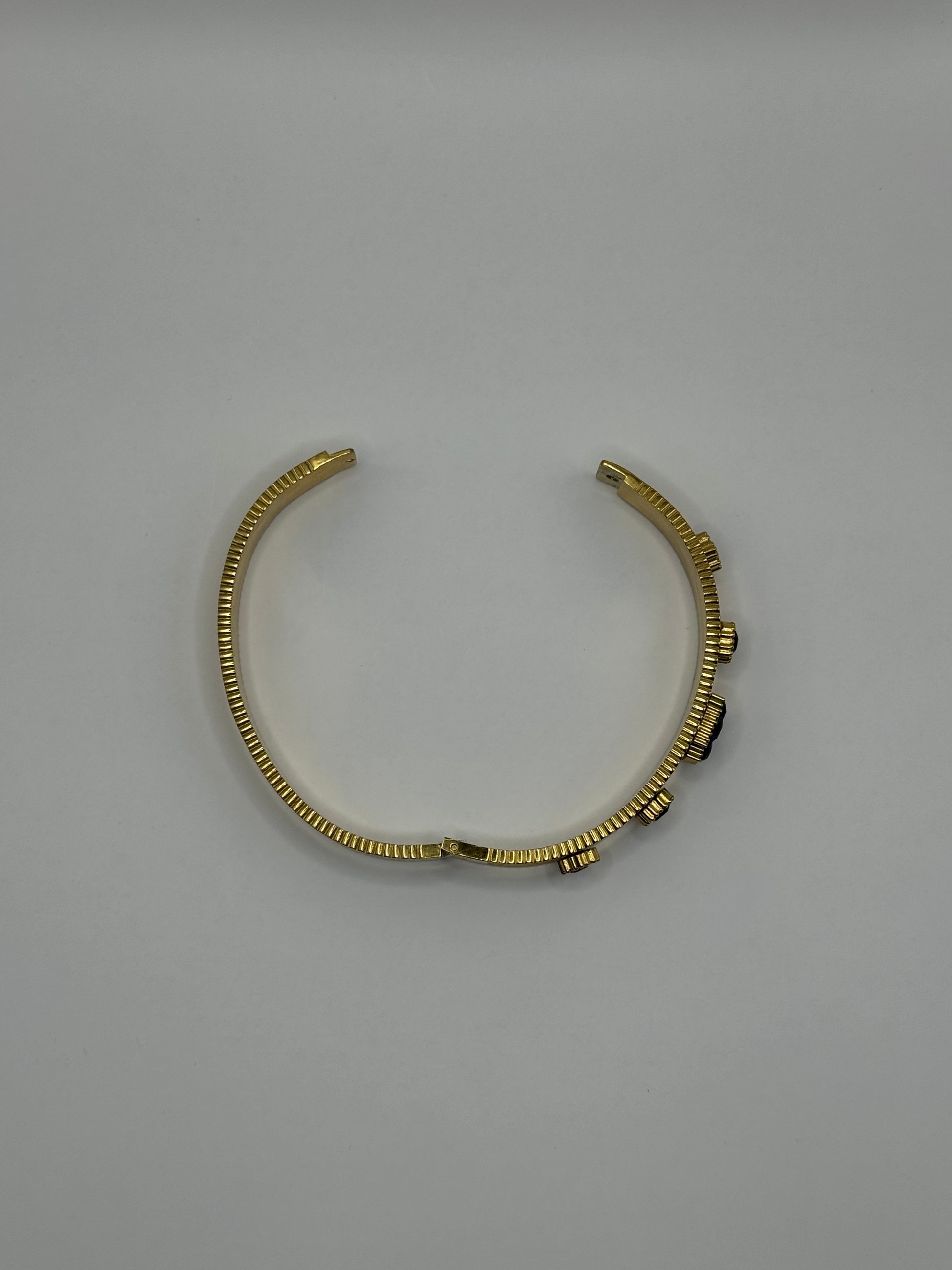 Flat lay of The Noctara Bracelet showing slim gold band with deep cobalt accents.