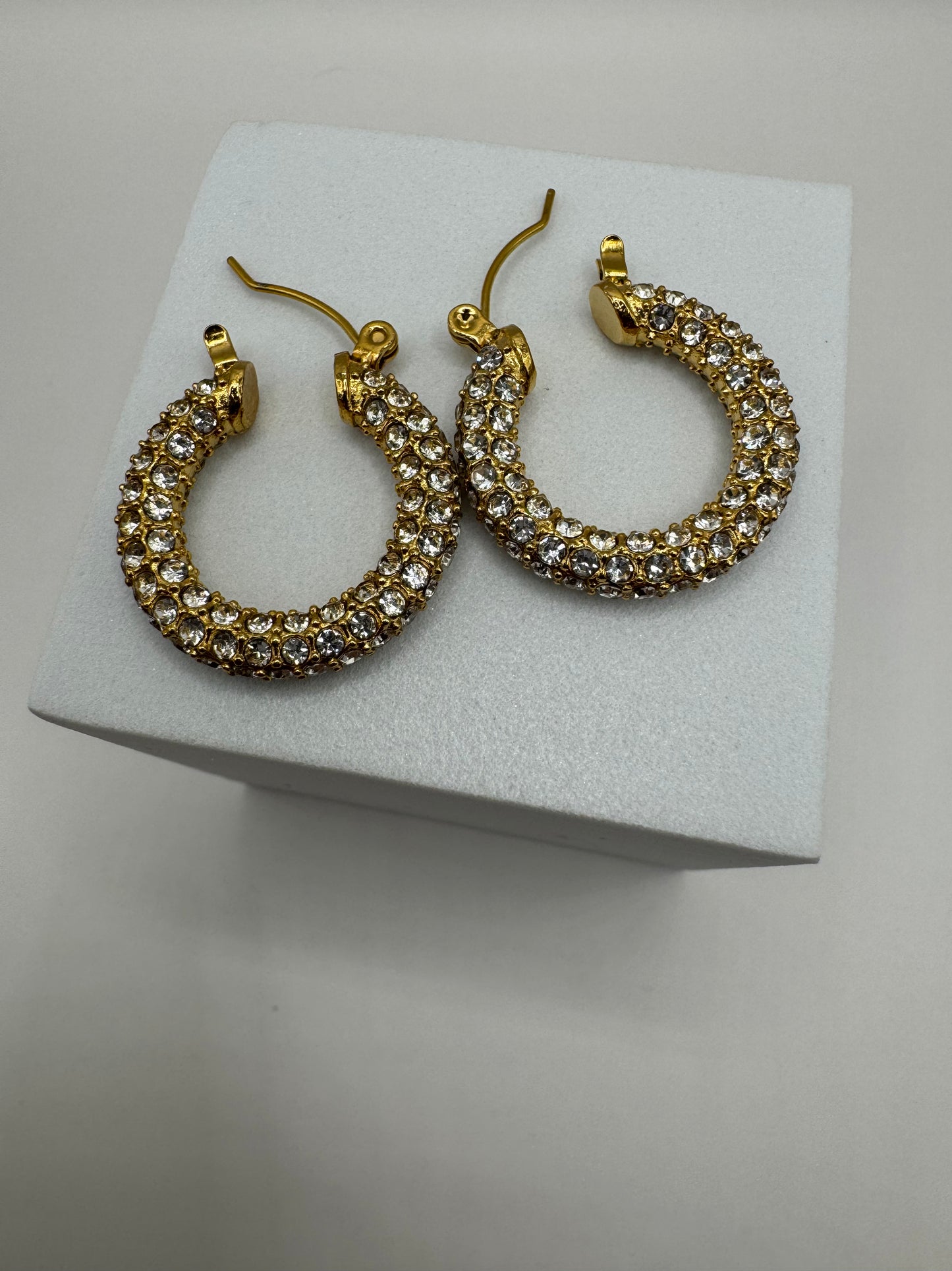 Side view of Aros Novina crystal hoops showing detailed gold-tone finish.