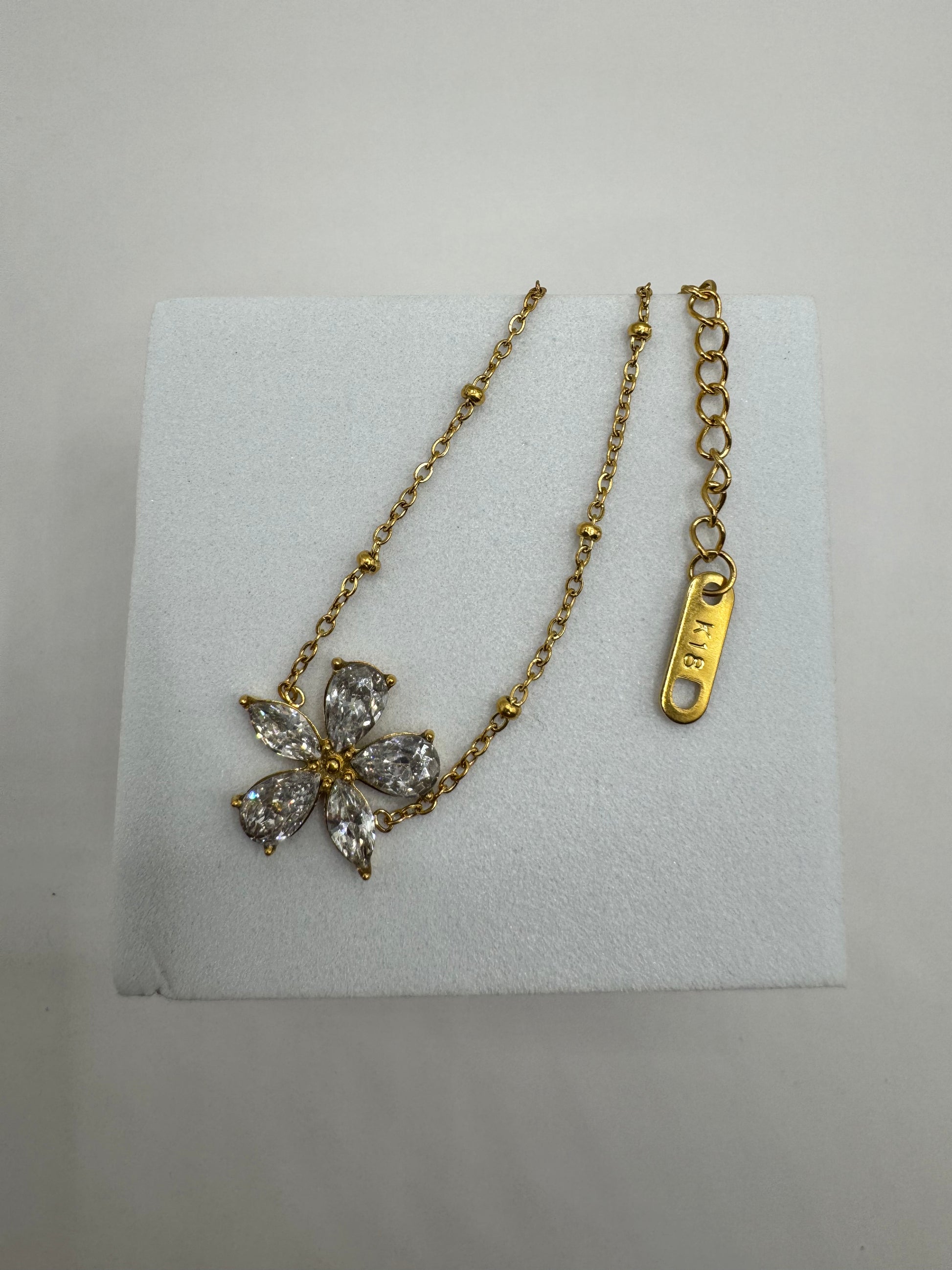 Close-up of The Zafira Bracelet showing delicate chain, zircon floral inlay, and adjustable gold extender clasp.