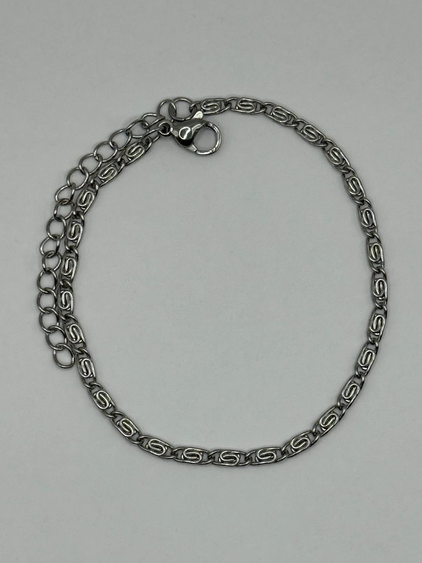 Elise Bracelet- stainless steel silver-tone chain arranged in a circular layout, showcasing modern geometric design.