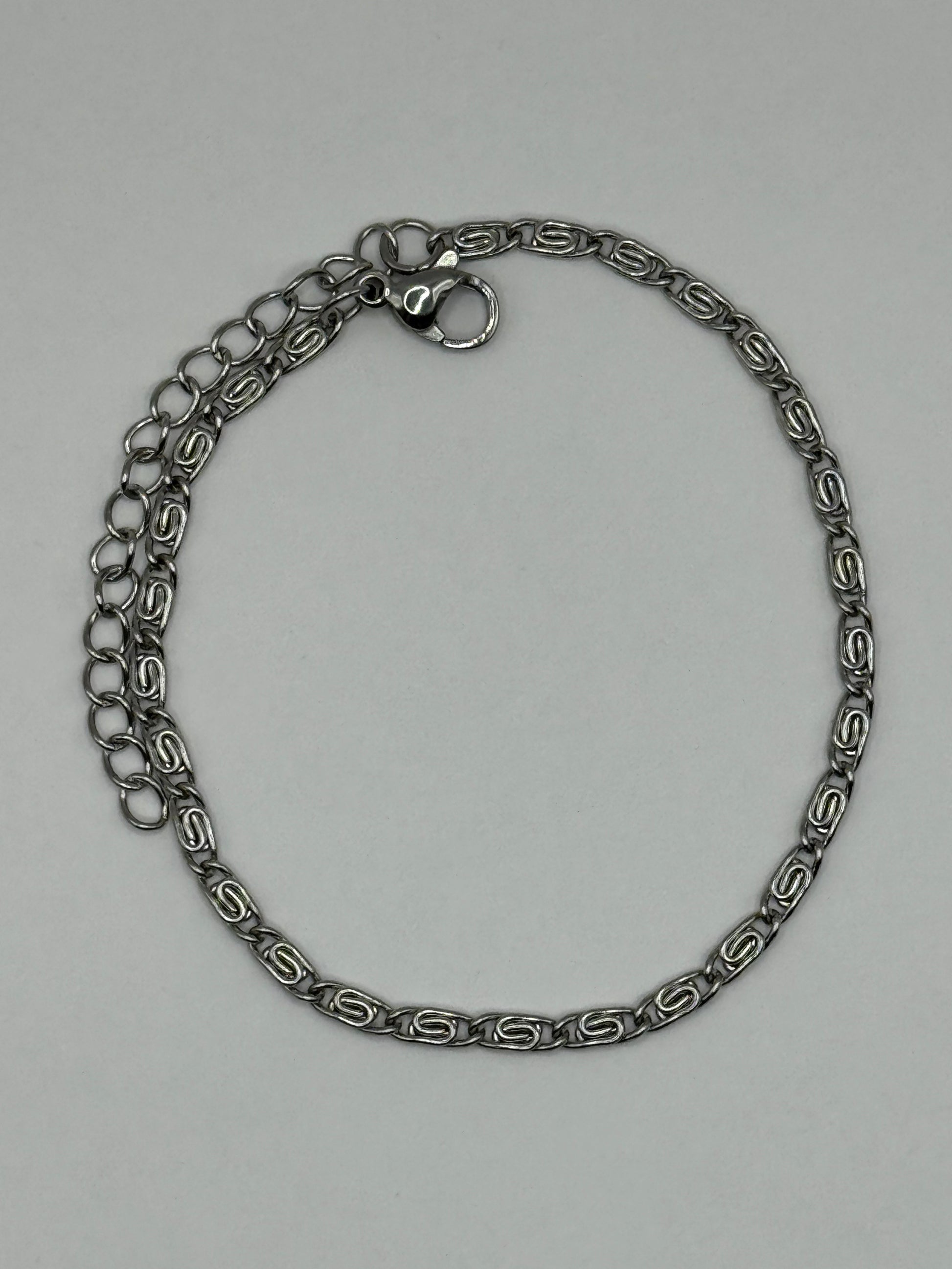 Elise Bracelet- stainless steel silver-tone chain arranged in a circular layout, showcasing modern geometric design.