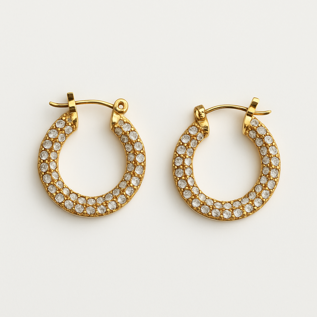 Close-up of Aros Novina gold-tone crystal-embellished hoop earrings on white background.