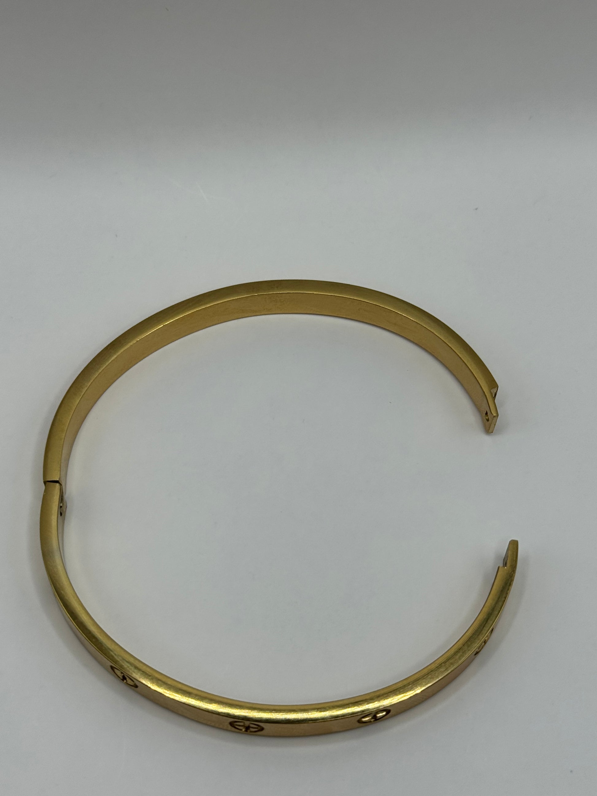 Flat lay of The Eterna Bracelet showing polished gold finish in circular shape.