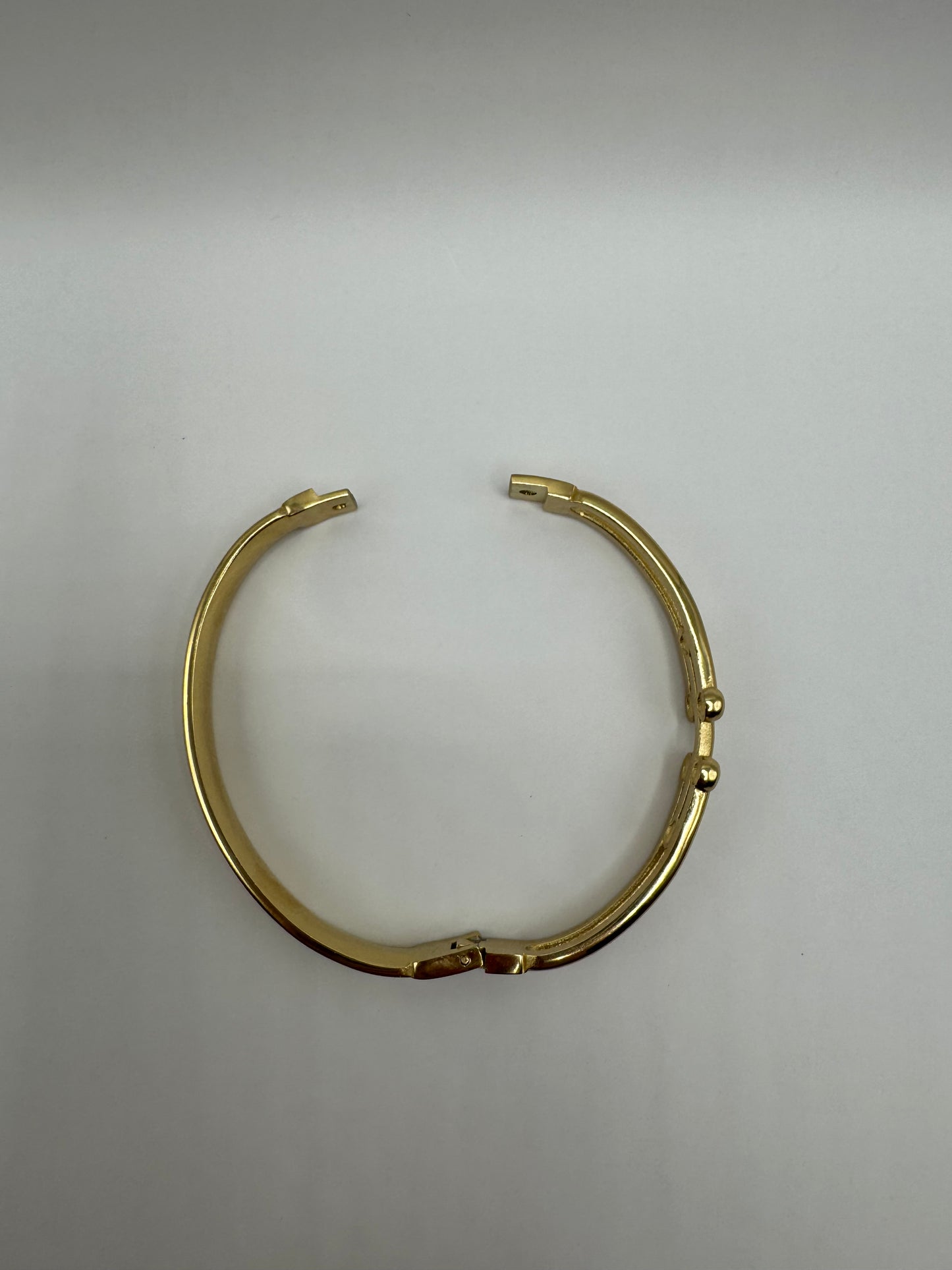 Top view of The Colette Bracelet laid flat, showing its circular gold-plated silhouette with subtle detailing.
