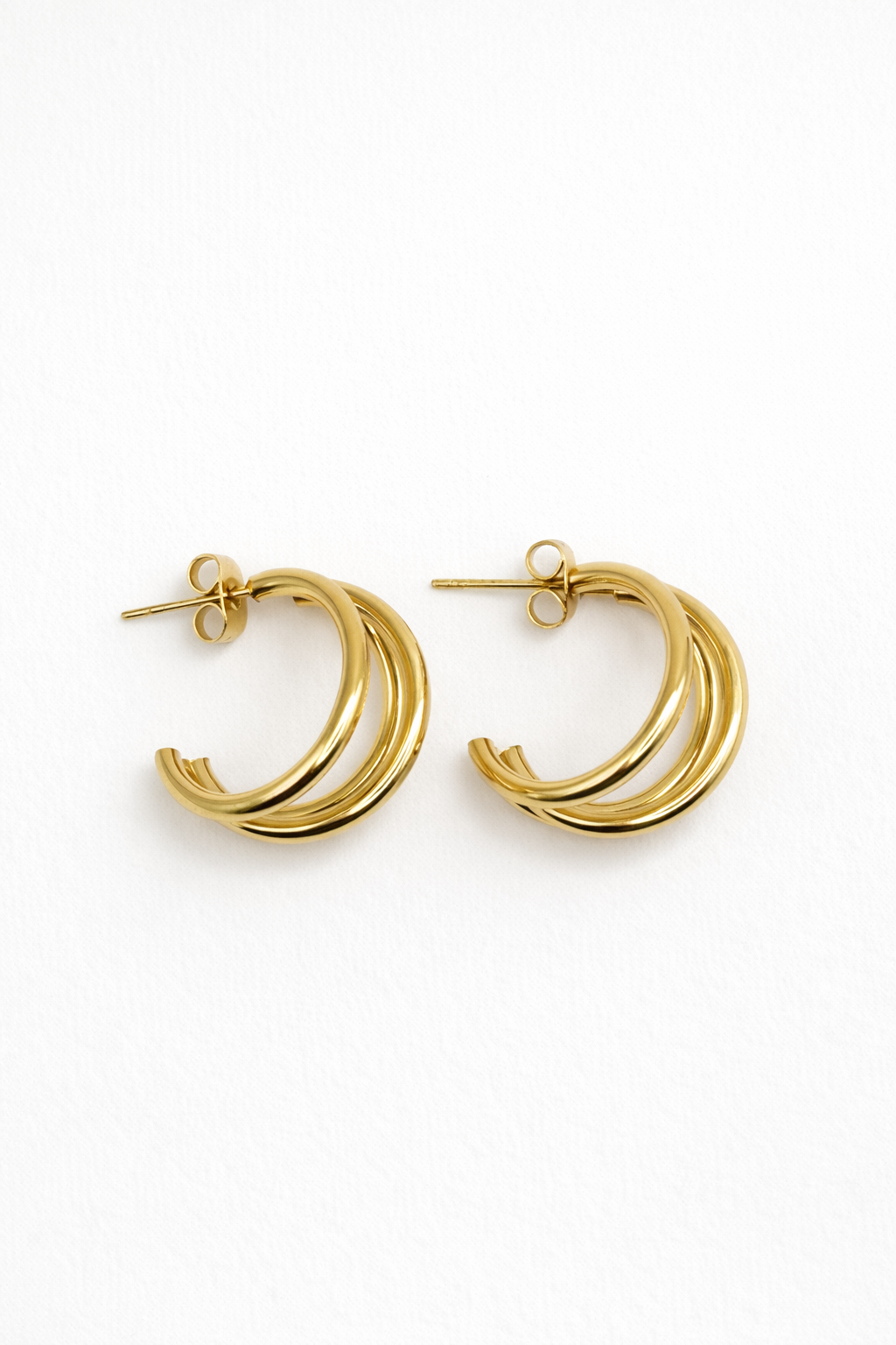 Gold double-band stacked huggie hoop earrings on a white background