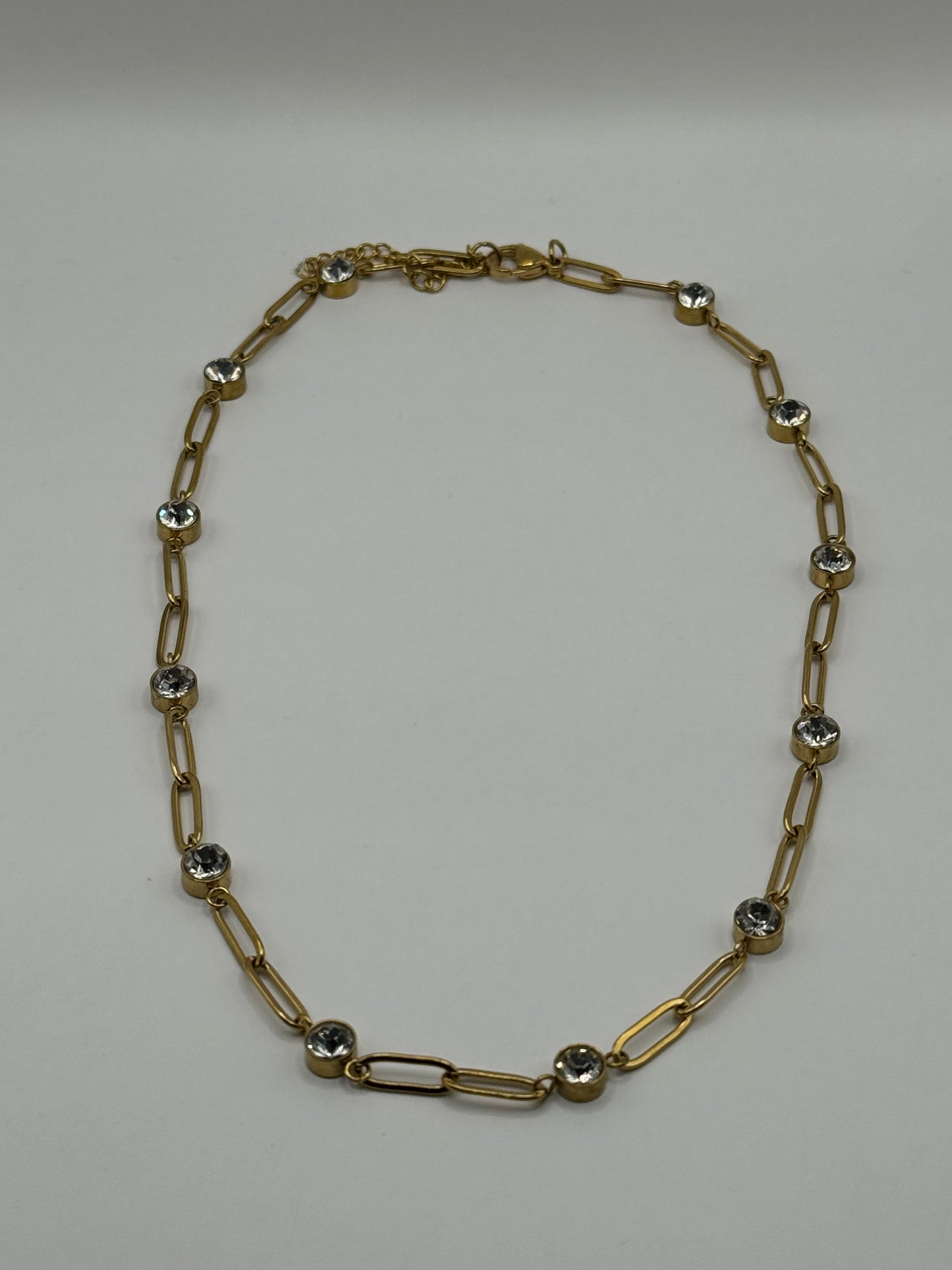 EMPIECE™ The Adelaide Necklace in gold, featuring a paperclip chain with clear crystal accents displayed flat on a neutral background.