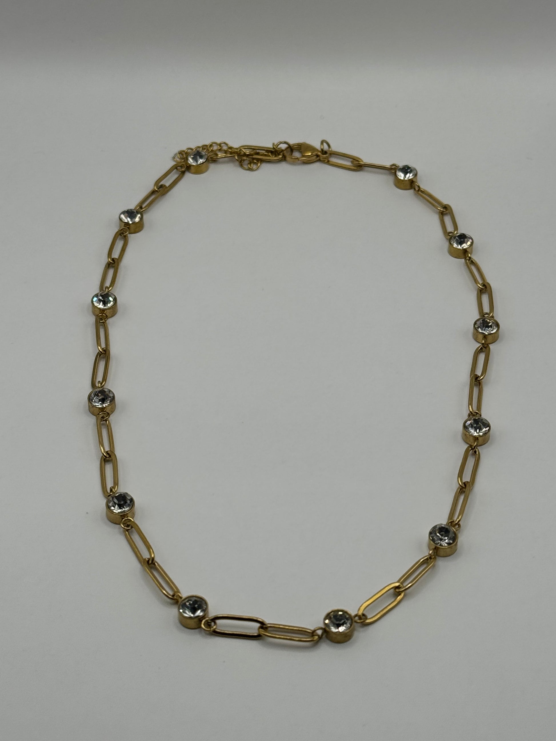 EMPIECE™ The Adelaide Necklace in gold, featuring a paperclip chain with clear crystal accents displayed flat on a neutral background.