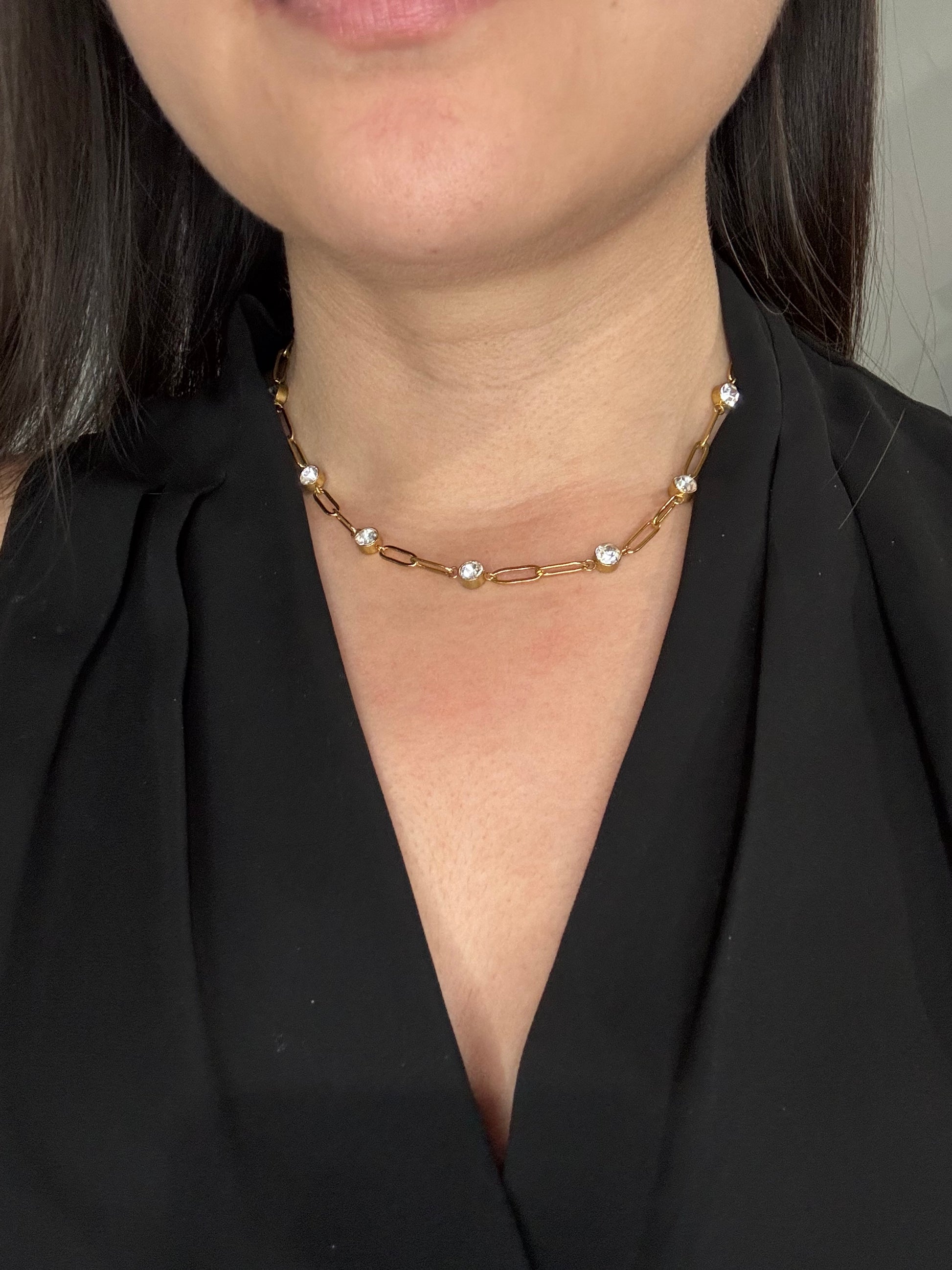 EMPIECE™ The Adelaide Necklace worn on model, featuring a gold paperclip chain with clear crystal accents styled at the neckline.