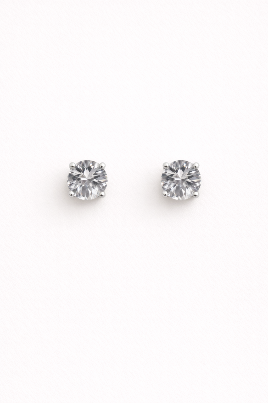 Round silver cubic zirconia stud earrings in polished stainless steel on a white background, The Ari Studs by EMPIECE™.