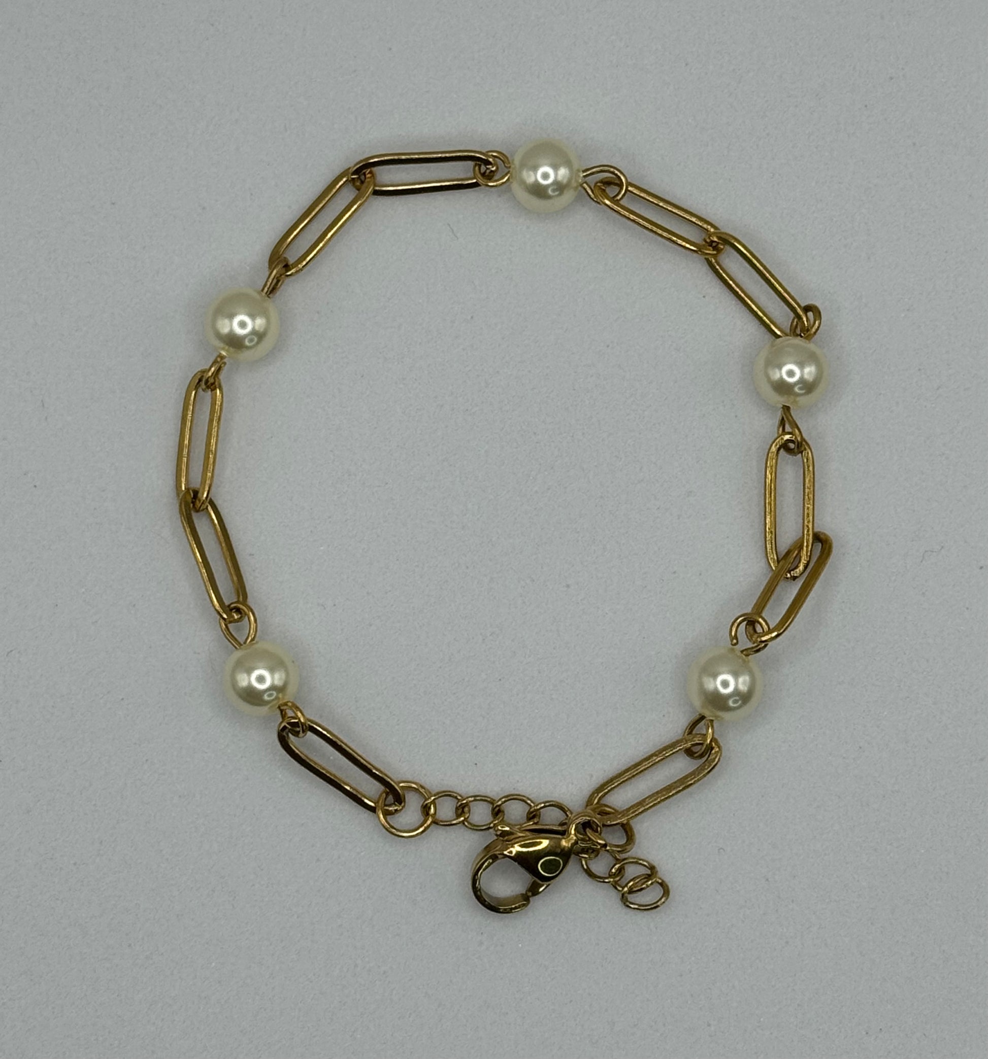 The Esther Bracelet by EMPIECE™, gold paperclip chain bracelet with pearl accents on a soft gray background