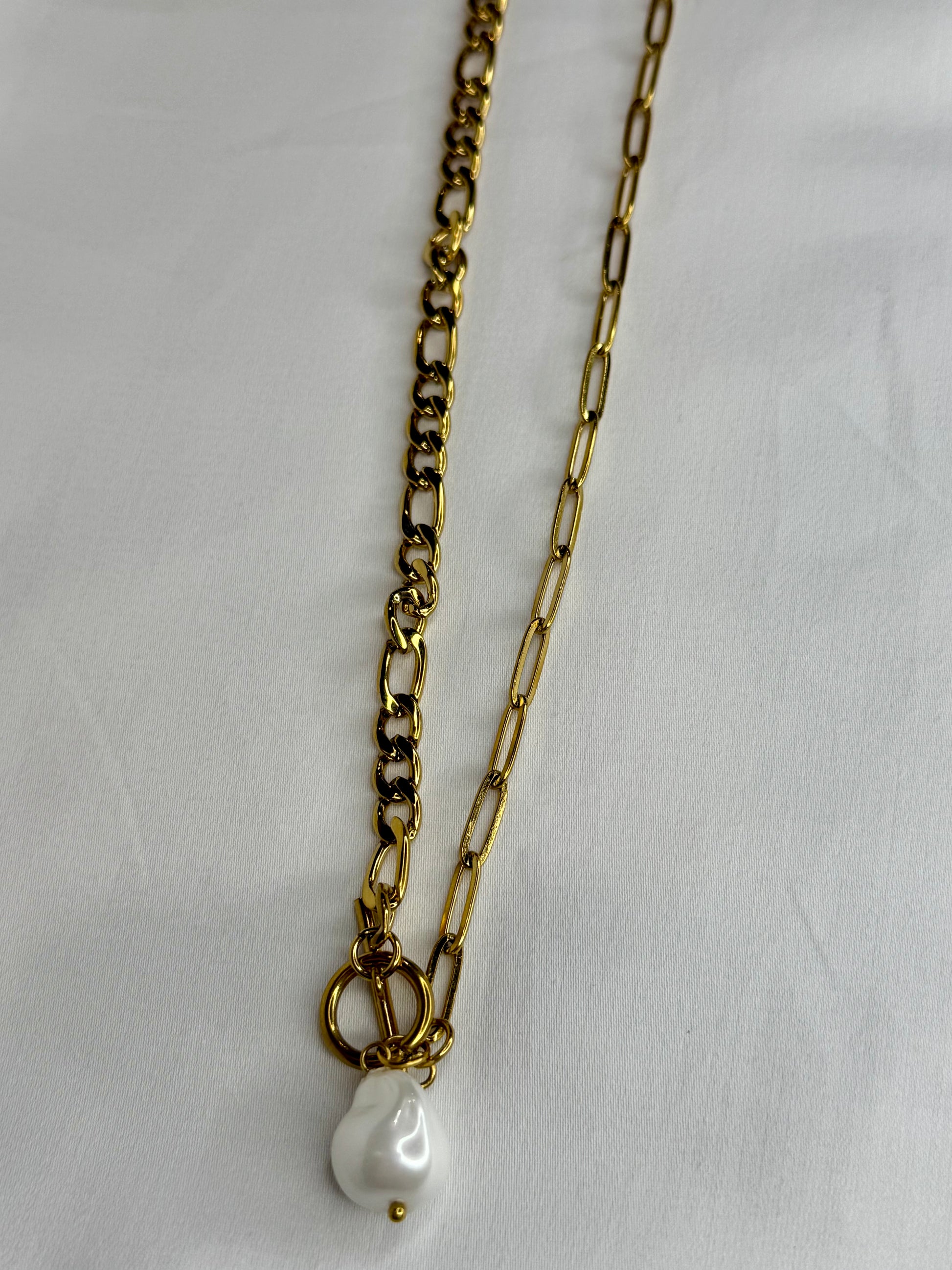 The Perla Necklace by EMPIECE™, featuring a layered gold chain design with a luminous pearl drop and toggle clasp detail.